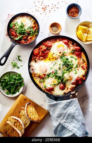 Shakshuka con verdure, erbe, salsa di pomodoro e fette di pane alla griglia Foto Stock