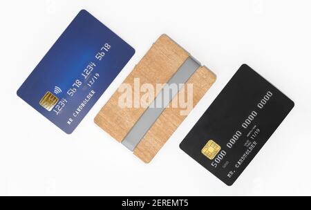Carte di credito bianche blu e nere ed elegante carta di legno supporto su sfondo bianco Foto Stock