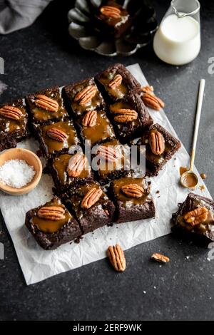 Turtle Brownies con caramello salato e croccante di pecan in una flatlay. Foto Stock