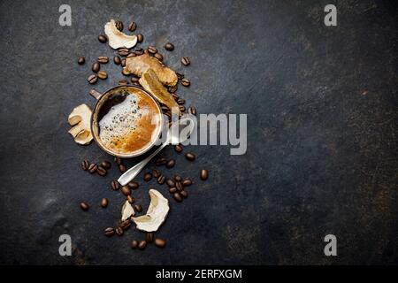 Funghi Chaga Coffee Superfood funghi freschi e freschi e chicchi di caffè su sfondo scuro. Spazio di copia, vista dall'alto. Concetto di trend cibo moderno Foto Stock