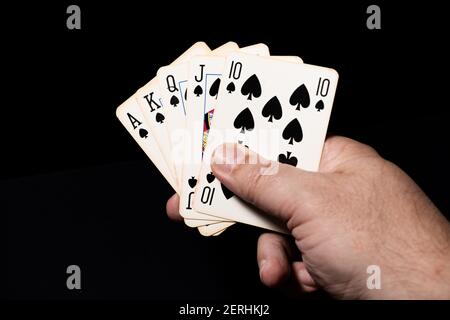 Pique Royal Flush in un gioco di poker. Sfondo nero. Foto Stock