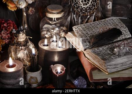 Candele brucianti e libro aperto con incantesimi magici sulla tavola delle  streghe. Sfondo esoterico, gotico e occulto, concetto mistico di Halloween  Foto stock - Alamy