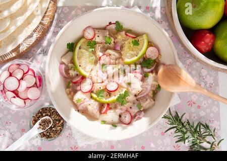Primo piano di una ceviche peruviana con pezzi di pesce e. limoni Foto Stock