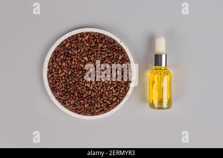 Olio di semi di pompelmo con acini d'uva su sfondo grigio con spazio copia. Cuscino per massaggio spa - calore naturale o confezione fresca. Medicina alternativa e terapia Foto Stock