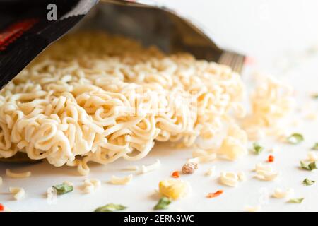 spaghetti istantanei, verdure secche e spezie su sfondo bianco Foto Stock