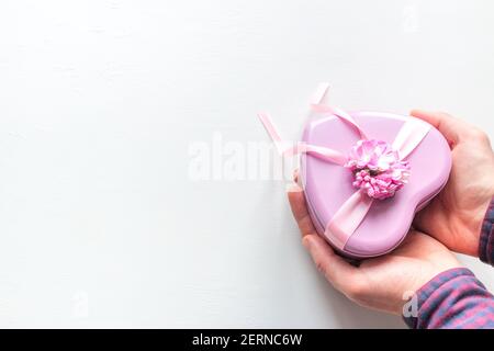 l'uomo dà un dono a forma di cuore Per San Valentino su sfondo bianco con spazio per testo Foto Stock