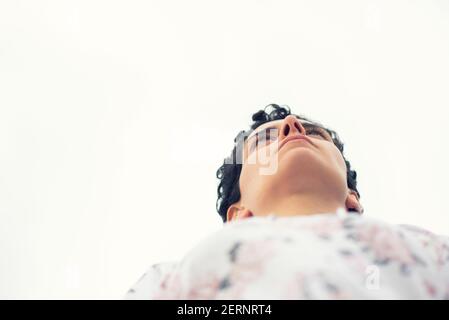 Vista ad angolo basso della donna che guarda lontano Foto Stock