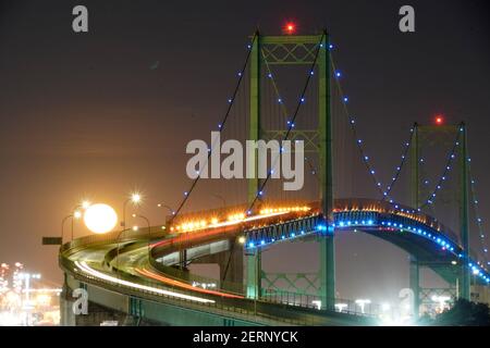 Una visione generale di una luna piena sul ponte Vincent Thomas, Domenica, 28 febbraio 2021, a San Pedro, Calif. Foto Stock