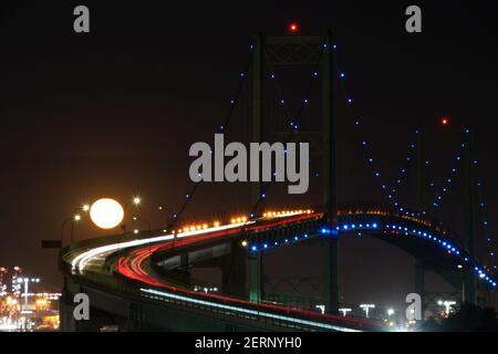 Una visione generale di una luna piena sul ponte Vincent Thomas, Domenica, 28 febbraio 2021, a San Pedro, Calif. Foto Stock