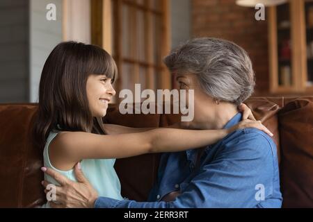 Sorridente nonna anziana e piccola nipote abbracciano Foto Stock