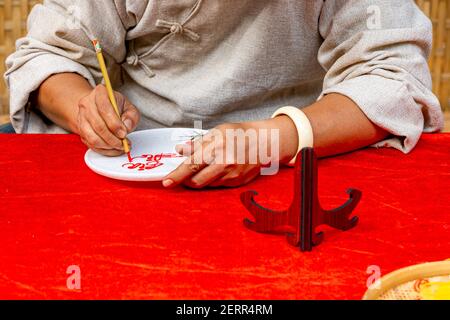 Primo piano foto di scrittura a mano umana con pennello calligrafia penna Foto Stock