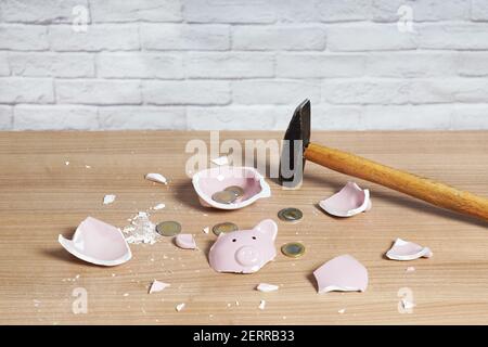Il banco di Piggy rotto ha frantumato in pezzi con il martello e piccolo o monete euro di cambio sciolto Foto Stock