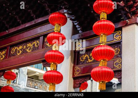 Lanterne rosse appese al piano superiore nell'arco in stile cinese Foto Stock