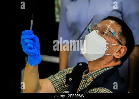 Manila. 1 marzo 2021. Francisco Duque III, segretario del Dipartimento della Sanità delle Filippine, esamina una siringa contenente un vaccino COVID-19 proveniente dal Sinovac cinese il primo giorno della vaccinazione presso il Lung Center delle Filippine a Manila, Filippine, il 1 marzo 2021. Le Filippine hanno lanciato la campagna di vaccinazione del coronavirus lunedì, a meno di un giorno dall'arrivo del vaccino Sinovac CoronaVac donato dalla Cina. Credit: Rouelle Umali/Xinhua/Alamy Live News Foto Stock