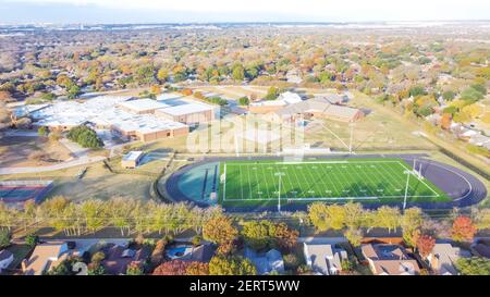 Campo da calcio scolastico con pista da corsa, gol di calcio e quartiere residenziale in linea orizzontale Foto Stock