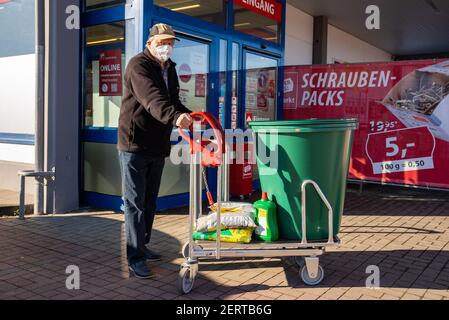 Neustadt bei Coburg, Germania. 01 Marzo 2021. Il cliente fai da te Günter si trova di fronte all'ingresso del negozio fai da te dopo lo shopping. In Baviera, i negozi di fai da te sono riaperti da oggi, insieme ai parrucchieri e ai centri giardino. Credit: Nicolas Armer/dpa/Alamy Live News Foto Stock