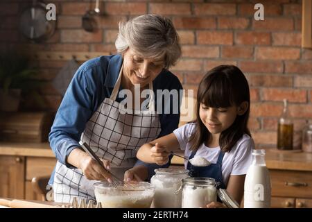 Buona nonna anziana e piccola nipote cuocere a casa Foto Stock