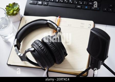 Microfono e cuffie sul tavolo, vista dall'alto. Ambiente di lavoro podcast radio Foto Stock