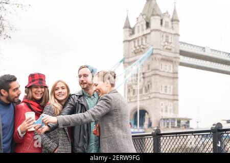 Gruppo felice che fa un selfie vicino a Tower Bridge. Studenti universitari che viaggiano in tutto il mondo. Turismo, viaggi, persone, tempo libero e adolescenti con Foto Stock