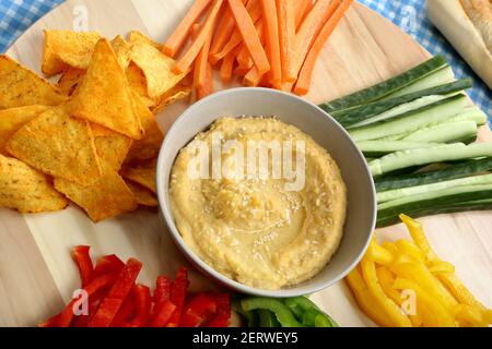 Hummus in una ciotola, spuntino vegetariano, cibo sano con verdure Foto Stock