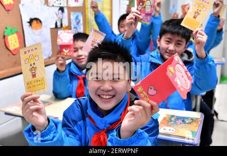 (210301) -- XI'AN, 1 marzo 2021 (Xinhua) -- gli studenti mostrano le carte dei desideri che hanno ricevuto alla Scuola sperimentale primaria nel distretto di Beilin di Xi'an, nella provincia di Shaanxi, nella Cina nord-occidentale, 1 marzo 2021. Il lunedì segna il primo giorno di un nuovo semestre di scuole medie e elementari a Xi'an. Gli studenti della scuola elementare sperimentale del distretto di Beilin sono stati accolti da speciali wish card dei loro insegnanti, promettendo loro di realizzare uno dei loro desideri nel nuovo semestre, tra cui l'innalzamento della bandiera nazionale, il pranzo con il direttore, abbracciando un insegnante preferito, saltando homewor Foto Stock