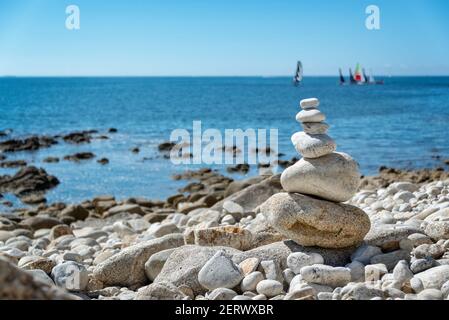 Mucchio di pietre su una spiaggia, sullo sfondo dell'oceano in Bretagna, Francia Foto Stock