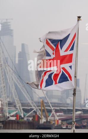 Una bandiera dell'Unione Britannica o Union Jack che batte con morbido Mettere a fuoco lo skyline di Londra sullo sfondo Foto Stock