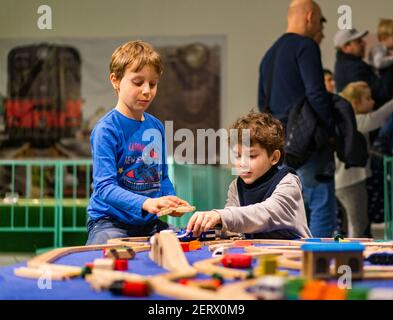 POZNAN, POLONIA - 27 gennaio 2018: Due ragazzi che giocano con treni giocattolo in legno in una mostra di Kolejkoland Foto Stock