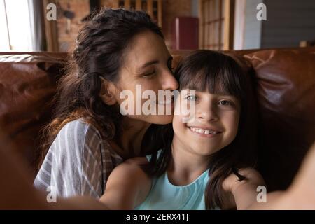 Piccola ragazza ispanica prendere selfie con mamma sorridente Foto Stock