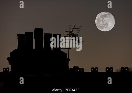 Luna piena che si erge su uno stack di Chimney della Casa di Londra Foto Stock