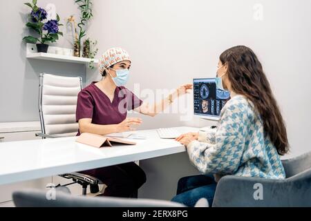 Foto di scorta del dentista femminile che mostra il suo giovane paziente a raggi X. Foto Stock