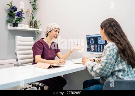 Foto di scorta del dentista femminile che mostra il suo giovane paziente a raggi X. Foto Stock