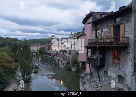 Vista lungo il fiume di una delle caratteristiche abitazioni sospese di Pont-en-Royans, nella regione Auvergne-Rodano-Alpi, durante il crepuscolo Foto Stock