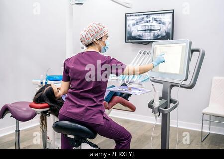 Foto di scorta del team di lavoro femminile in clinica dentale che esamina una radiografia. Foto Stock