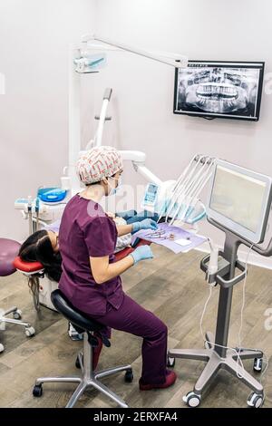Foto di scorta del team di lavoro femminile in clinica dentale che esamina una radiografia. Foto Stock