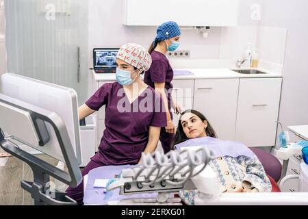Foto di scorta del team di lavoro femminile in clinica dentale che esamina una radiografia. Foto Stock