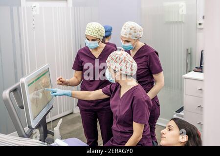 Foto di scorta del team di lavoro femminile in clinica dentale che esamina una radiografia. Foto Stock