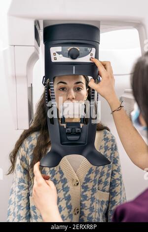 Foto di scorta di un dentista non riconosciuto che utilizza una macchina a raggi X con il paziente. Foto Stock