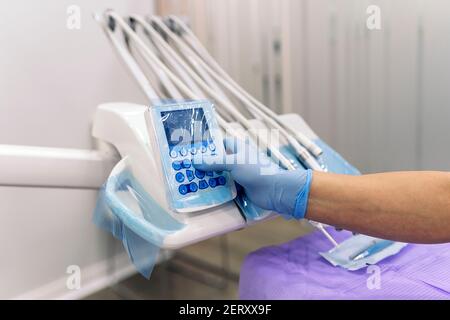 Foto di scorta di dentista senza volto utilizzando apparecchiature mediche in clinica odontoiatrica. Foto Stock