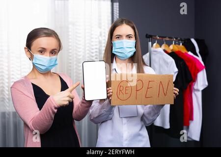 Riaprire il concetto del negozio dopo la pandemia del coronavirus. Si prega di indossare una maschera facciale e mantenere la distanza per proteggere da Covid-19. Forefinger per scherzare Foto Stock