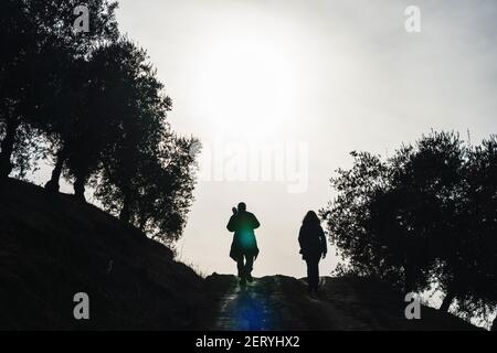 Foto di amici non riconosciuti che camminano in campagna e indossano zaini. Foto Stock
