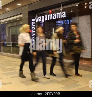 Persone che camminano oltre un ristorante Wagamama Foto Stock