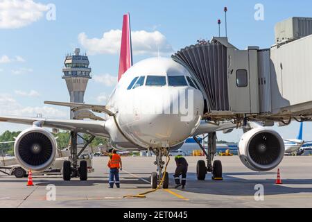 L'aeromobile è collegato alla passerella terminale del edificio dell'aeroporto durante il rifornimento prima del volo Foto Stock