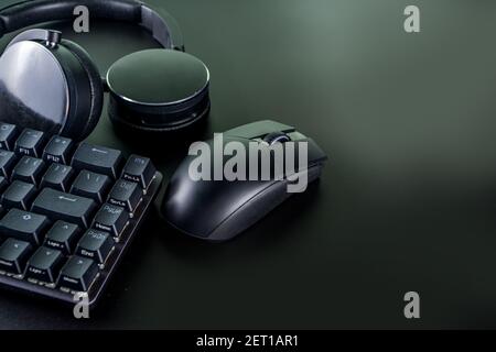 Concetto di dispositivi di gioco e di gioco. Spazio tavolo di lavoro del giocatore sfondo, vista dall'alto. Tastiera, mouse, joystick gamepad, tappetino per mouse e cuffie. Su t nero Foto Stock
