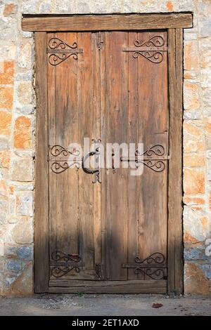 Antica porta tradizionale in legno con serrature in metallo, in una casa in pietra, sull'isola di Skiathos, Grecia. Foto Stock