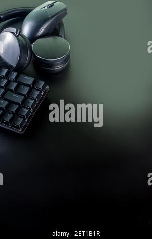 Concetto di dispositivi di gioco e di gioco. Spazio tavolo di lavoro del giocatore sfondo, vista dall'alto. Tastiera, mouse, joystick gamepad, tappetino per mouse e cuffie. Su t nero Foto Stock