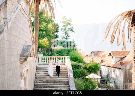 La sposa e lo sposo scendendo le antiche scale di La Natività della Beata Vergine Maria a Prcanj Foto Stock