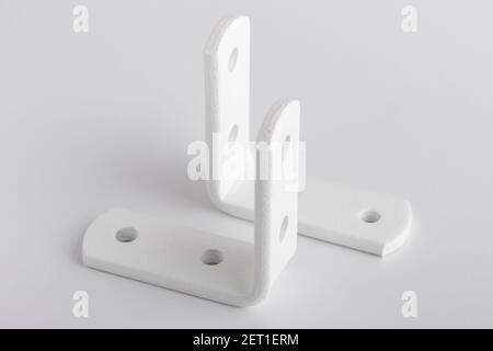 Angoli metallici per il montaggio su sfondo bianco. Angoli per il fissaggio di armadi Foto Stock