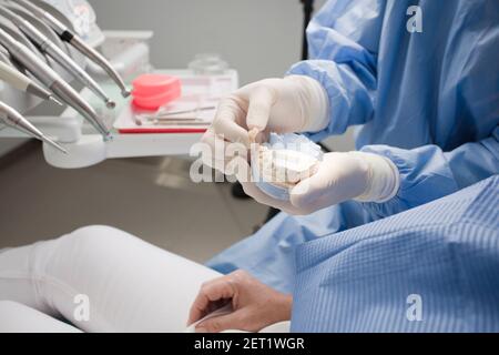 dentista con dente in mano e mandibola nell'altro. Foto Stock