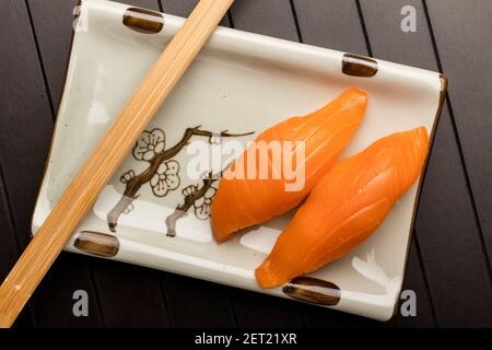 Sushi con salmone su un piatto con chopsticks Foto Stock
